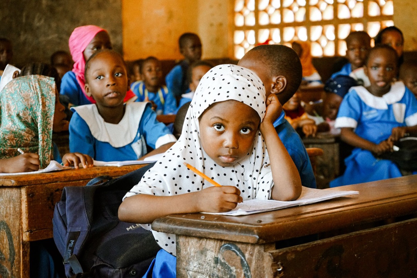 A schoolgirl concentrating at her desk in a Ghanaian classroom