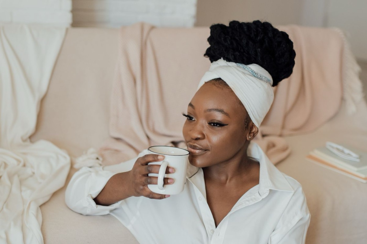 A woman relaxing calmly at home with a warm drink